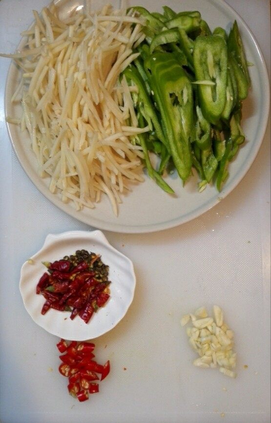 青椒土豆丝,改刀切丝,干红辣椒剪成段,大蒜切片