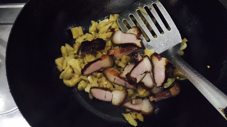 萝卜干毛豆炒腊肉,焖3分钟后,放入准备好的腊肉片,翻炒均匀。