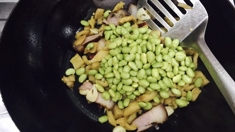 萝卜干毛豆炒腊肉,接着放入毛豆,翻炒均匀。