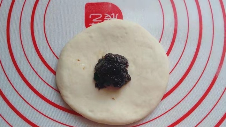 红糖椰蓉三角包,醒好后取一份小面团擀成圆饼,不要太薄,然后捏一份红糖馅放入中间;
