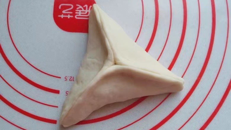 红糖椰蓉三角包,接着将三条边捏合起来即好;