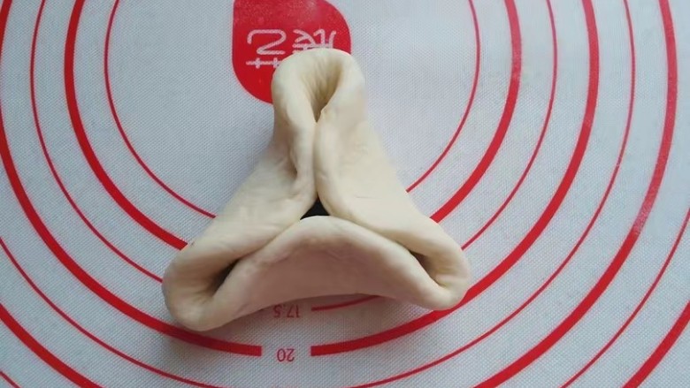 红糖椰蓉三角包,先将边缘向中间捏出三条边;