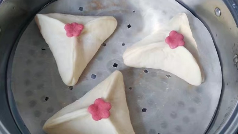 红糖椰蓉三角包,将包好的三角包放入蒸锅中,饧发20~30分钟;冷水或温水上蒸锅,开中火至上汽时,大火蒸10~15分钟后,关火后再虚蒸3~5分即好。