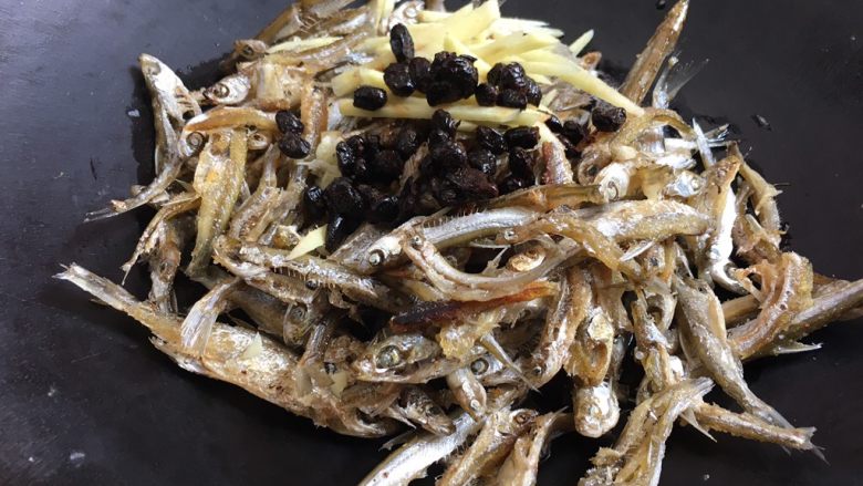 豆鼓焖河鱼,接着开火加油,放蒜炒一下再放鱼、豆鼓、姜,加一点开水!开水的量是刚好收汁的量,不需要太多!