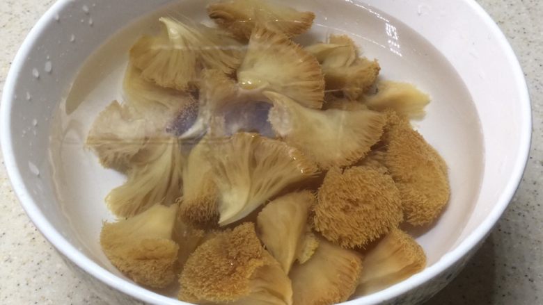 荷香蒸猴头菇鸡腿肉(附如何清洗猴头菇),洗到猴头菇揉捏后水还是清澈的没黄水就可以了。剪去蒂部,撕成一朵朵。