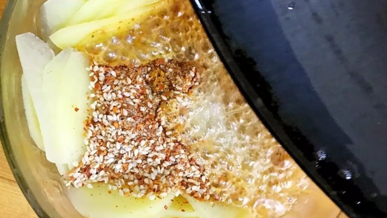 凉拌土豆片,热锅倒入适量的食用油,油烧热后淋在辣椒粉上