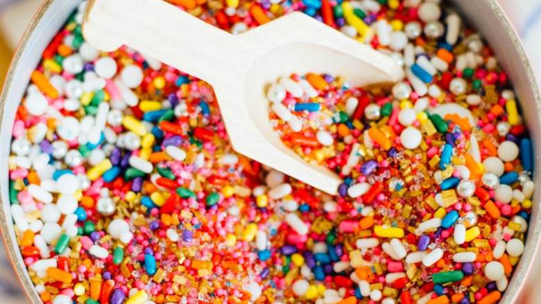 咖啡牛奶鸡尾酒配迷你甜甜圈,混合牛奶（1汤匙），糖粉（1/4杯）至均匀，把玻璃杯沿在糖霜中蘸一下，然后再在彩色糖针（1/4杯）蘸一下。