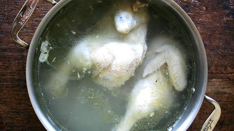 墨西哥鸡肉塔可,把一个1.3千克-1.8千克的鸡 放入大汤锅中,加入冷水没过鸡肉。煮开,关火,盖上锅盖,静置25分钟。