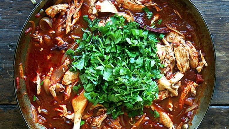 墨西哥鸡肉塔可,微微煮开后小火炖煮15分钟。把香菜加入到锅中,翻拌均匀。尝一下味道,不够咸的话再加一些盐。