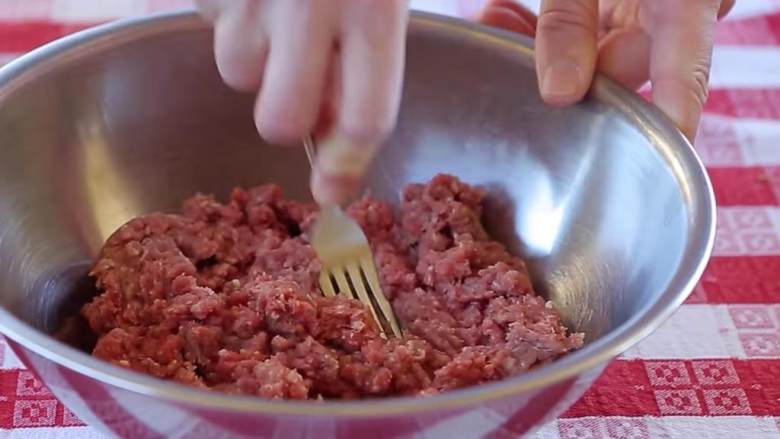 意大利肉丸,把混合猪肉牛肉 放入碗中,用叉子背部按压,翻面继续。