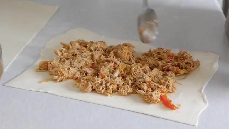 快手鸡肉派,接着,把鸡肉和蔬菜均匀地铺开在派皮上。