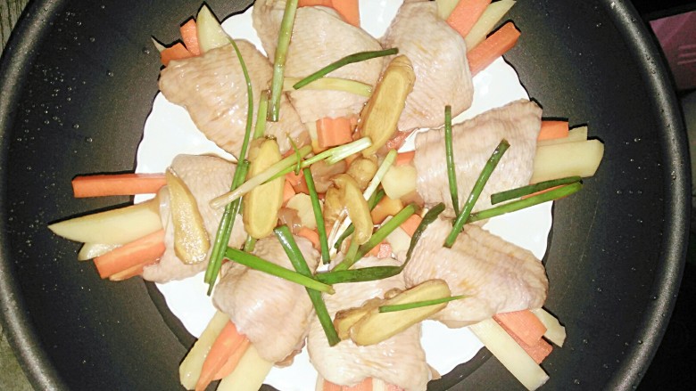 胡萝卜土豆酿鸡翅,把腌制鸡翅的姜葱,酱汁倒入鸡翅里,上锅蒸25分钟就好了