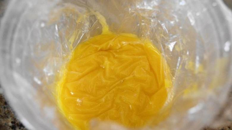 自制柠檬凝乳,接着,把凝乳舀到一个干净的容器中,顶部盖上保鲜膜,防止结皮;接着盖上盖子密封;放入冰箱冷藏至少3个小时,然后就可以用到各种各样的料理中了。