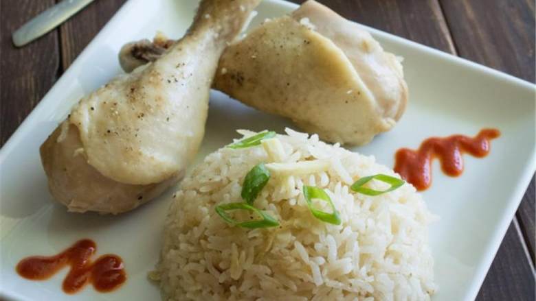 电饭煲海南鸡饭,取出鸡腿,用叉子或者筷子把饭戳散;米饭搭配鸡腿和辣酱 ,一起吃,撒上葱花 做装饰。