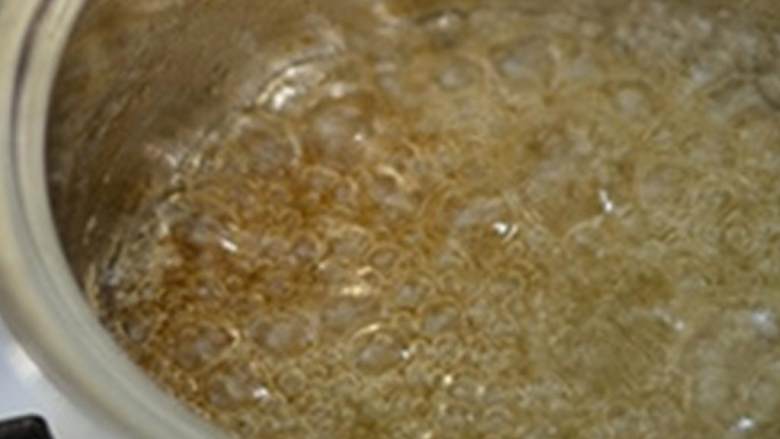 苹果库纳法派,首先来做焦糖 ;中高火加热,用木勺轻柔搅拌,到糖完全融化。