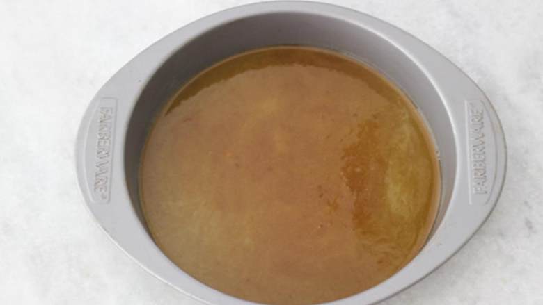 香蕉翻转蛋糕,碗中混合融化的黄油 ,红糖 ,朗姆酒 ;把混合物倒入准备好的蛋糕模中。