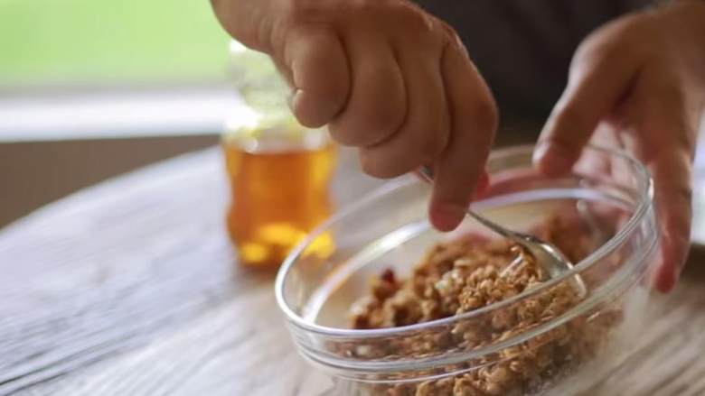 格兰诺拉蜜瓜叠叠高,每个碗中都淋上一点蜂蜜 ,搅拌均匀,这起到了粘合剂的作用。