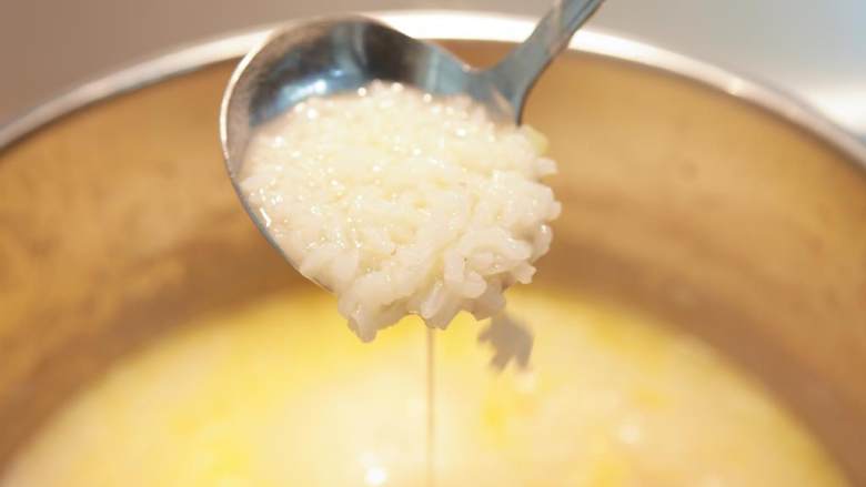 妈妈牌鸡肉生姜粥,将鸡肉移到盘子里,洋葱和生姜留在鸡汤里,加入生香米 ,中火煮30分钟,加入鱼露 (1 汤匙) ,用胡椒调味,撕开一些鸡肉放到锅里