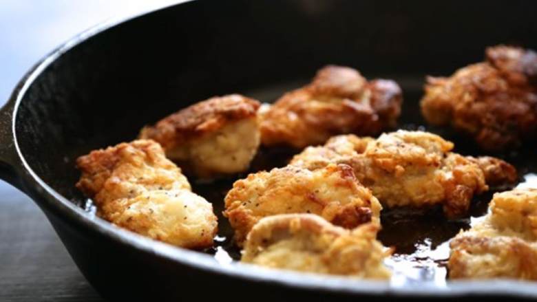 炸鸡华夫饼泥配蜂蜜,加入植物油 在直径25厘米的铁锅里，开中高火，将鸡腿放到面粉里再捞出来放进锅里，甩开多余的面粉，重复步骤，每边炸5分钟