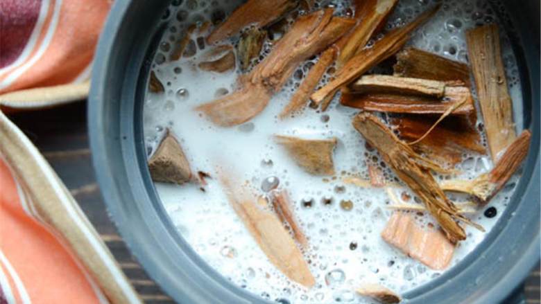 干红辣椒啤酒罐烤鸡,浸泡好木片后,将它们移动香烟盒中,将香烟盒直接放在燃烧炉上,它就是你的热源,打开煤气炉至中高火,约175度,当白烟出现时,可以开始烧了