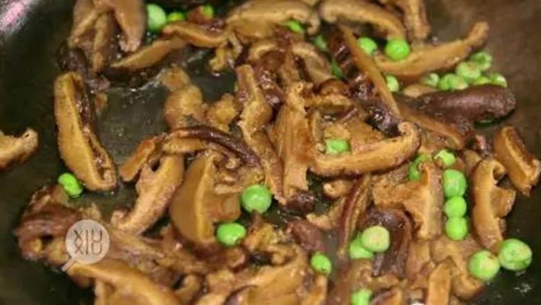 香菇油饭,热锅,倒入食用油后,加入干香菇 和豌豆 ,大火炒香;