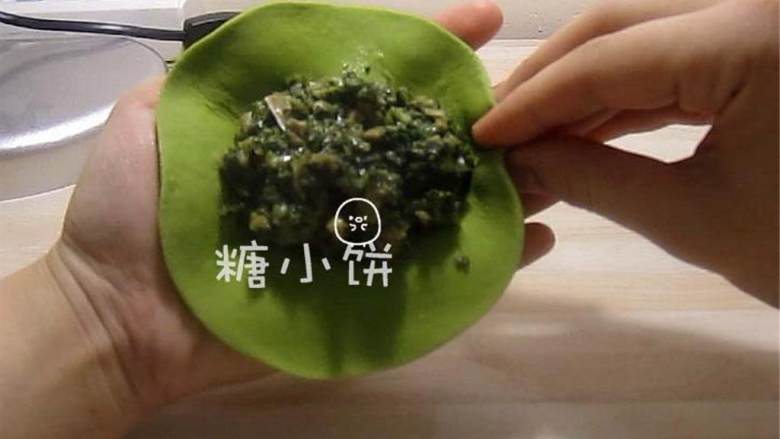 菠菜柳叶包,一只手托着面皮,另一只手的大拇指和中指捏着外面食指抵着里面,大拇指和中指向食指处一捏形成最初的褶子。