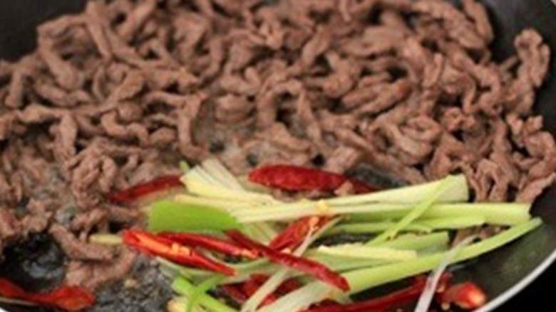 干煸牛肉丝,倒油 ，中火炒生姜丝 、葱 和干辣椒 。