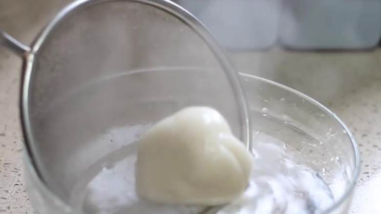 麻团,烧一锅开水,把面团放进去煮2-3分钟;另外准备一个碗,盛冷水;面团煮好之后,把它转移到冷水中,水要没过面团,使其冷却。