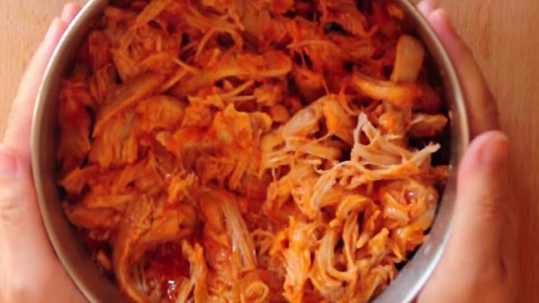 三种芝士布法罗风味鸡肉玉米脆饼,取一个大号沙拉碗,混合鸡肉鸡肉碎 和法兰克牌布法罗风味辣酱