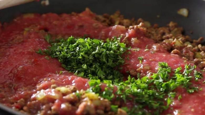 牙买加素牛肉饼,加入切碎的绿葱 、切好的新鲜欧芹 、去皮并切块的熟番茄 和蔬菜高汤 ,炖30分钟,进行收汁 。