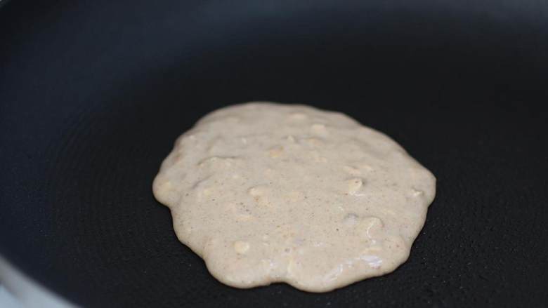 香蕉燕麦煎饼,用中火热锅,取大概1/4杯的混合物,轻轻地倒进锅里,煎至一面开始冒泡,然后翻面直至煎熟。