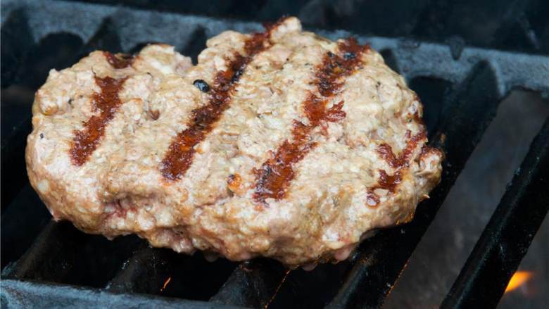 培根芝士牛肉堡,把牛肉饼放在烤架上,每面烤3到4分钟,在快烤好时,把芝士撒上去。