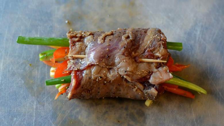 香煎牛排卷,用牙签固定牛肉卷。重复上述步骤,直到卷好剩下的所有牛肉和蔬菜。