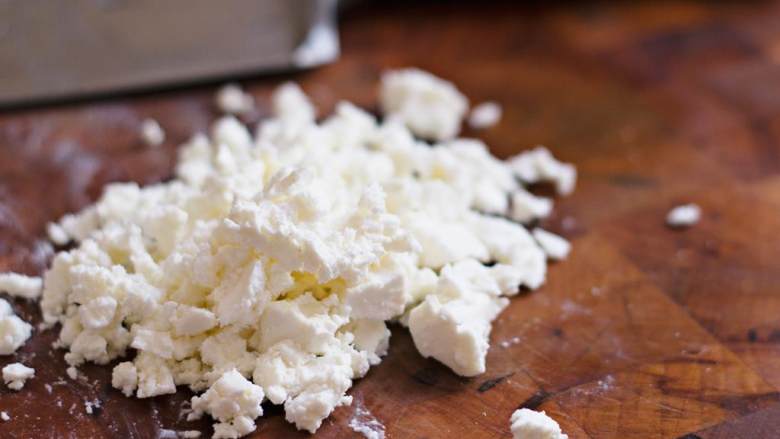 希腊烤羊肉皮塔三明治,将菲达芝士 切碎。