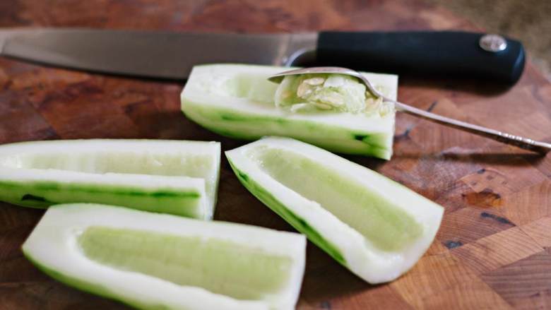 希腊烤羊肉皮塔三明治,现在来做希腊酸奶黄瓜酱——黄瓜削皮，纵向切成两半，舀出黄瓜里的籽。