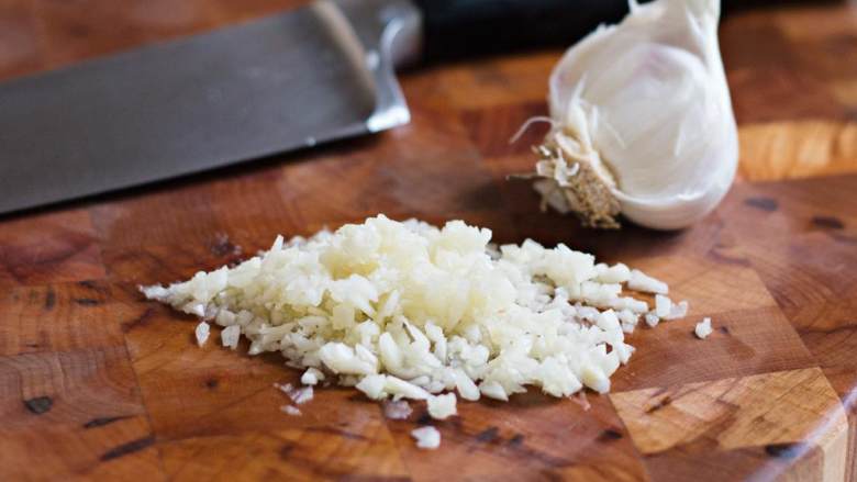 希腊烤羊肉皮塔三明治,将大蒜瓣 切碎。