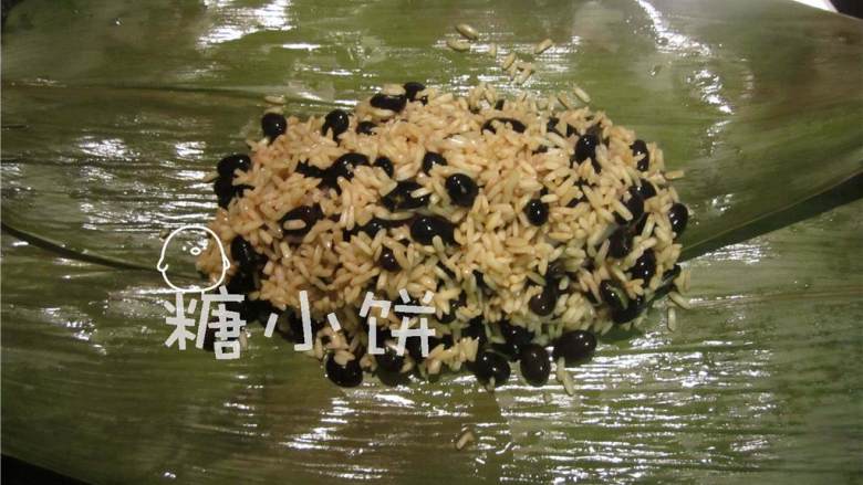 黑豆腊肠枕头粽,再铺上黑豆糯米盖住腊肠