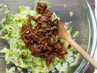 地中海风味火鸡肉丸,把炒好的西葫芦盛出，和洋葱放在同一个碗里，倒入酸豆 和番茄干 ，搅拌均匀。