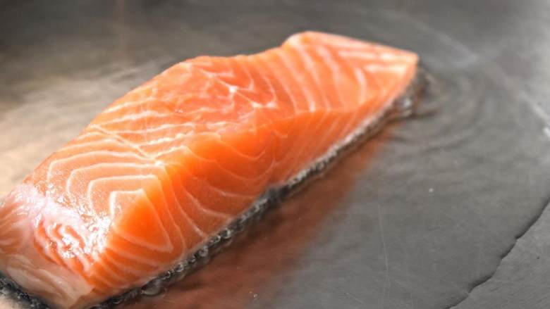 喷烤三文鱼,加入菜油之后,立马放入三文鱼腩 ,鱼皮面朝下。在朝上一面洒上粗盐 和新鲜新鲜研磨胡椒 ,煎3到4分钟。