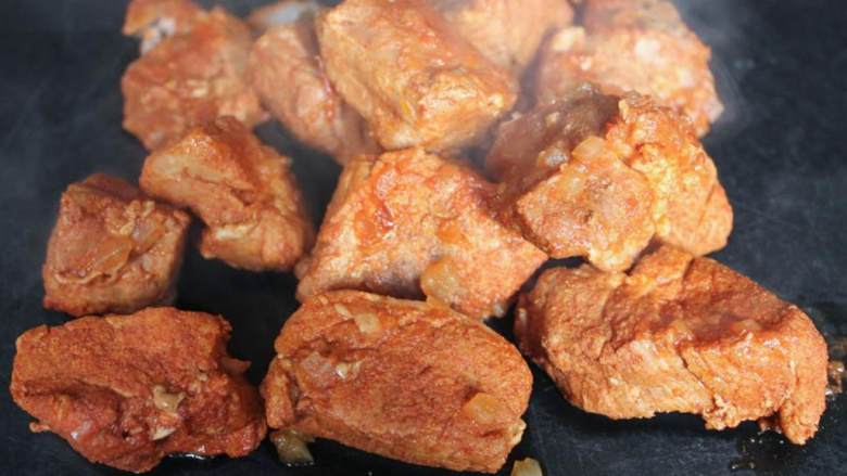 墨西哥辣里脊烤南瓜卷饼,1小时后,用汤匙或钳取出锅中的猪肉,把煮熟的肉放在砧板上。与此同时不要盖上炖锅的锅盖,让锅中的酱汁在低火上继续煮一会。