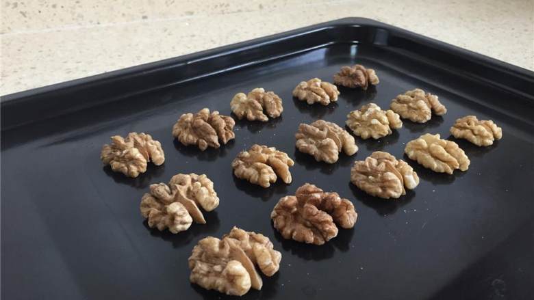 燕麦核桃酥,170度烤箱预热5分钟,核桃仁放入烤盘,进烤箱烤5分钟后取出冷却。