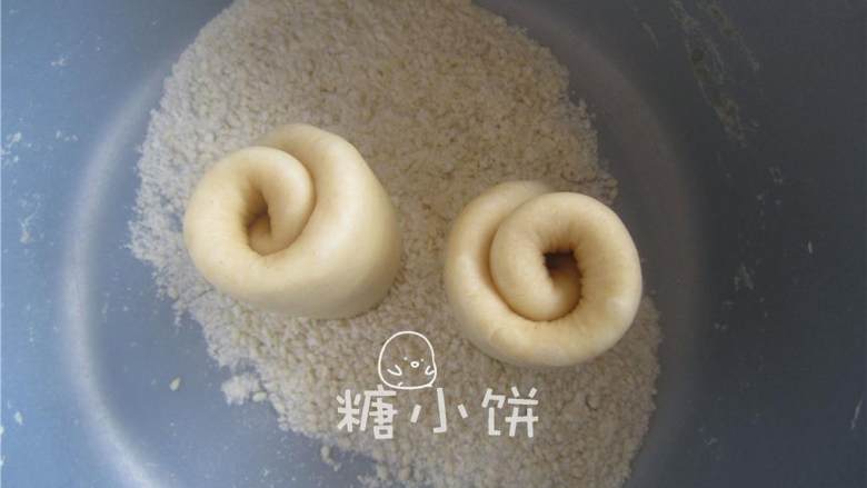香甜柔软脆底蜂蜜小面包,在一个盘子中混合小面包的底部蘸料,将白砂糖(1/2 汤匙),淀粉(1/2 汤匙)和白芝麻(1/2汤匙)混合均匀。取一个生坯竖起来,将底部(对半切开后的切面处)抹一点清水后粘满混合好的蘸料。