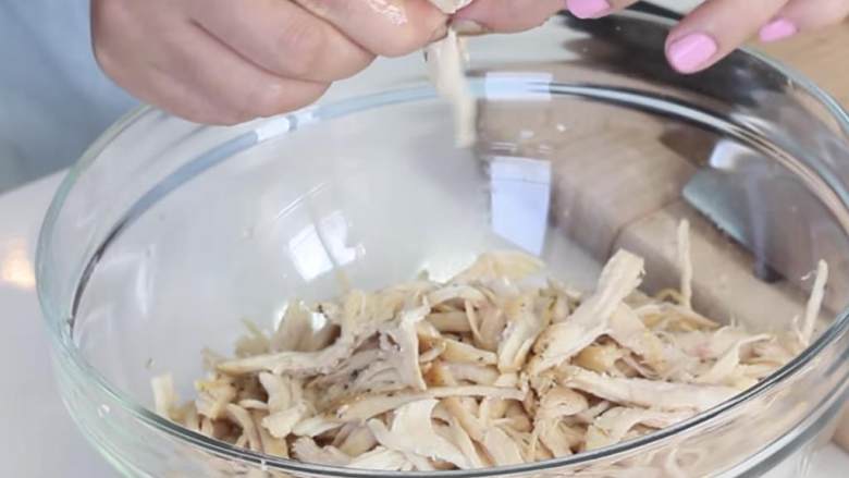 苹果鳄梨鸡肉色拉,等鸡肉完全冷却后,在大碗中撕碎它。