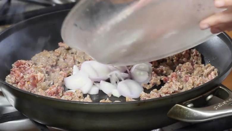 香肠配球芽甘蓝意大利面,当香肠基本煮熟后, 加入葱,和香肠一起煮。 直到葱煮软至半透明,香肠也已煮熟。将它转移到碗或盘中。