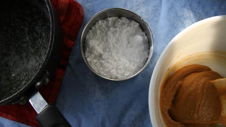 烤香蕉甜甜圈,从火上移开后加入花生酱(1/2 杯)搅拌。加入糖粉(1/2 杯)和~!@#$%^&*~ (2 汤匙或水，搅拌至水状。