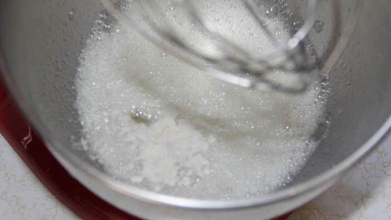 传统草莓酱天使蛋糕,当蛋白变浓稠后,放入剩下的糖,一次加入一汤匙。继续高速搅拌直到干性发泡。加入橙子屑(1 1/2 杯) 和纯香草精。