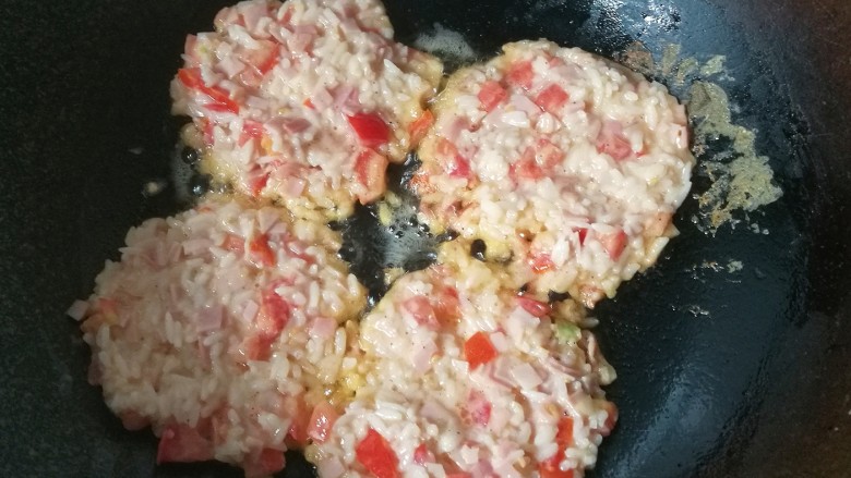 番茄火腿米饭饼,锅中放少许油小火加热,然后将米饭糊均匀地分成4份,放入锅中摊成米饭饼;
