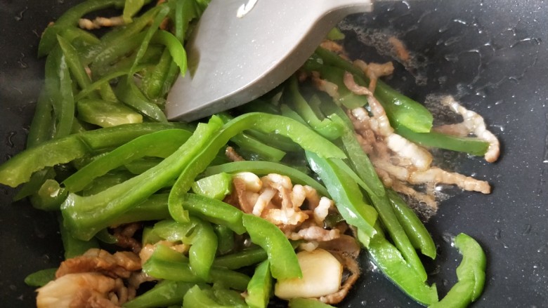 快手下饭菜:青椒肉丝,放入青椒,翻炒均匀。
