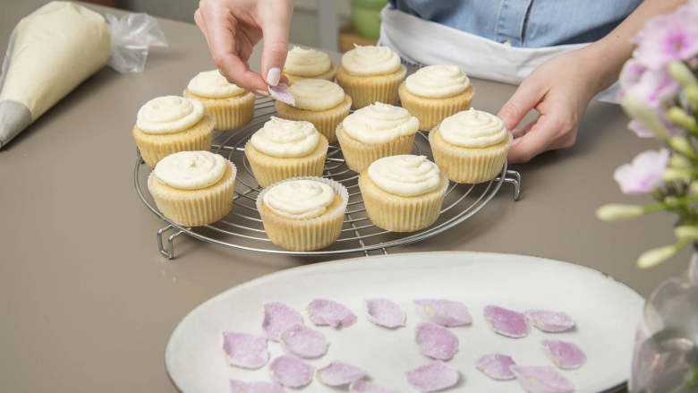 婚礼纸杯蛋糕,Frost the cupcakes by working your way from inside out, drawing upwards in circles. Decorate each cupcake with a sugarcoated rose petal. Enjoy!