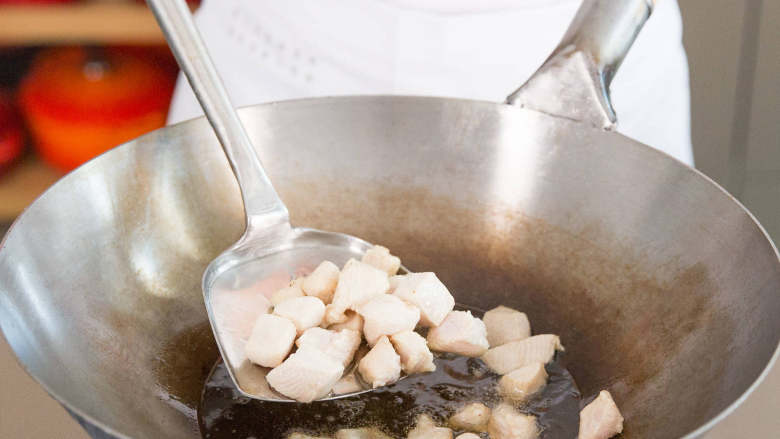 宫保鸡丁,将鸡肉倒入炒锅中,翻炒6-7分钟,炒熟为止。倒入厨房纸中,置于一旁。勾芡汁不要一起倒入。